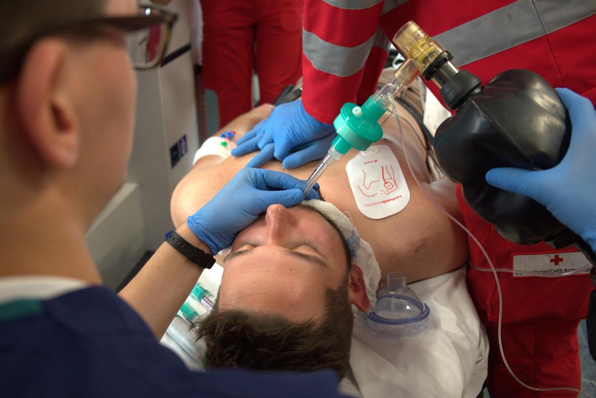 Ambulancepersoneel neemt de reanimatie over met beademing en professionele apparatuur