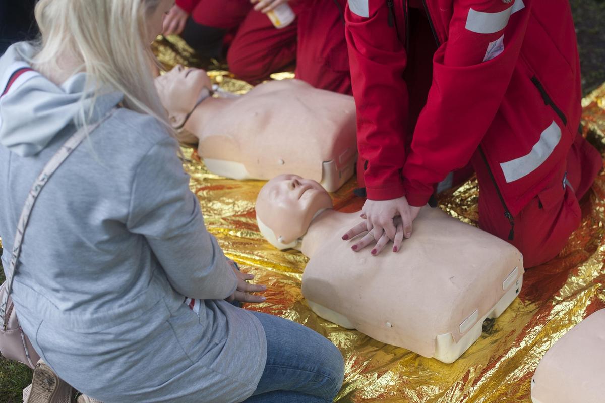 Cursisten oefenen borstcompressies op een reanimatiepop tijdens een reanimatietraining